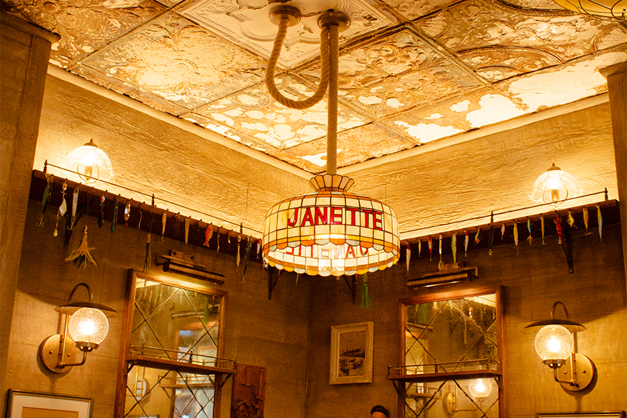 Lustre en vitrail suspendu au plafond d’un restaurant vintage, éclairage personnalisé dans une ambiance rustique chic