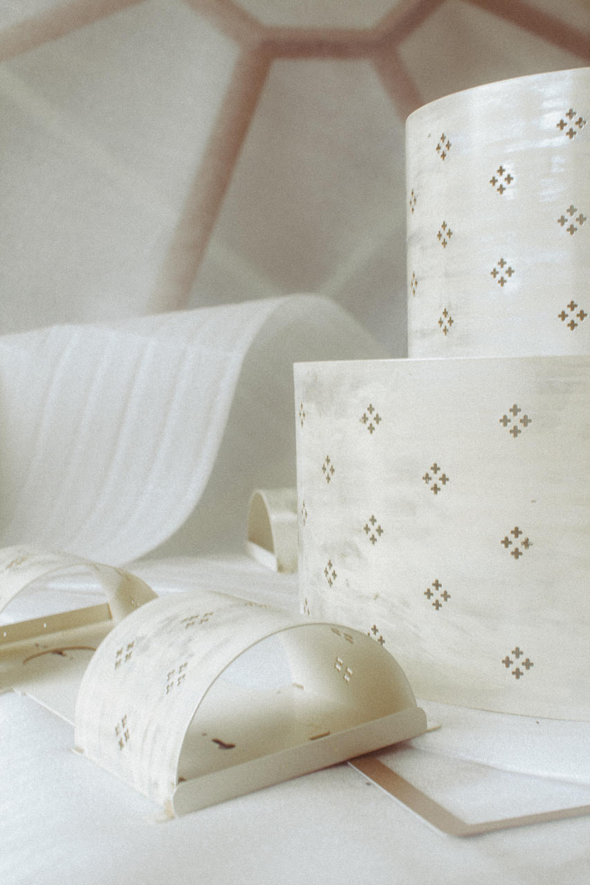 Éléments ajourés en laiton ou métal doré aux motifs en croix, en cours de fabrication artisanale pour luminaires décoratifs haut de gamme