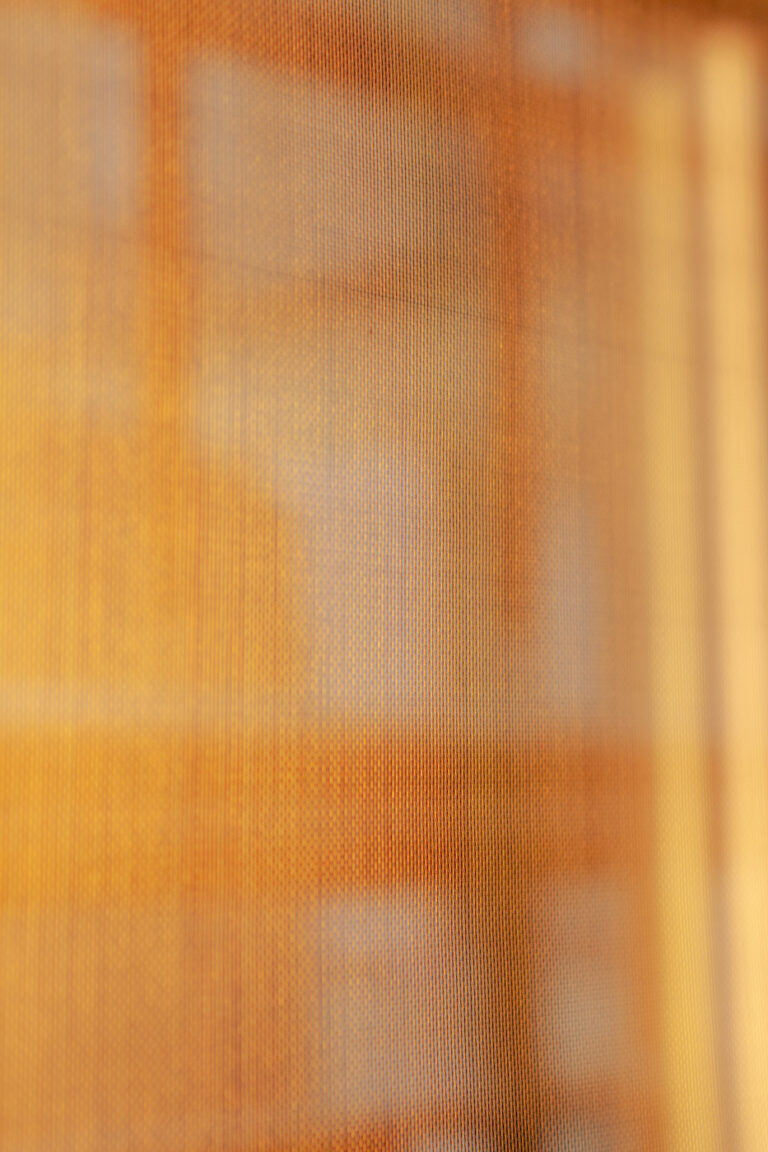 Détail de tissu lumineux rétroéclairé doré, matériau utilisé pour luminaires design personnalisés et créations d’éclairage sur mesure